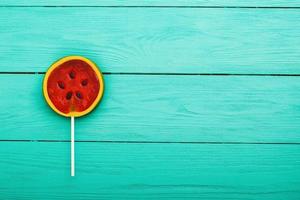 Watermelon summer candy food on blue wooden background. Top view. Mock up. Copy space. Sweet Lollipop photo