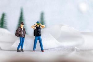 miniatura personas mochilero viaje en invierno hora foto