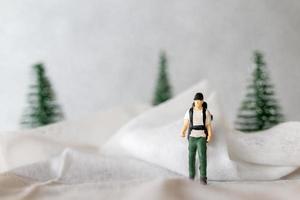 miniatura personas mochilero viaje en invierno hora foto