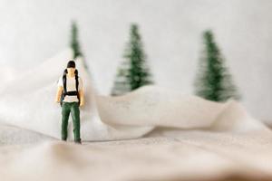 miniatura personas mochilero viaje en invierno hora foto