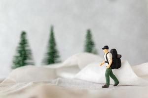 miniatura personas mochilero viaje en invierno hora foto