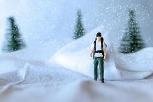 miniatura personas mochilero viaje en invierno hora foto