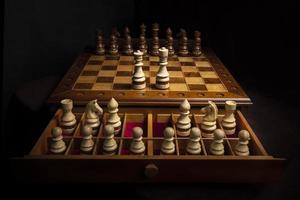 Chess pieces of wood on a beautiful chessboard. A puzzle game with tricky combinations that requires planning and thinking. photo