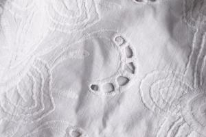 White cotton fabric background with embroidery. A piece of lace fabric. photo