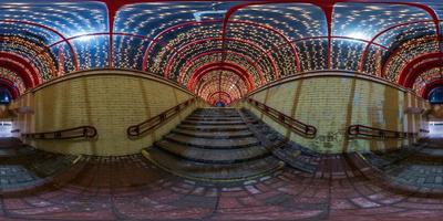 spherical night 360 panorama in festively lit underground passage tunnel with red frame arch and transparent dome and concrete staircase in equirectangular seamless projection, for VR AR content photo