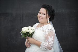 Beautiful fat bride posing with a bouquet of flowers on a dark background. photo