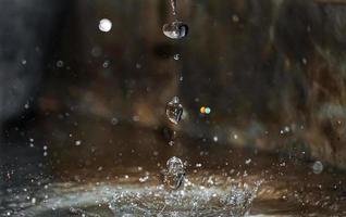 redondo lluvia gotas que cae en suave superficie de agua. foto