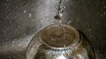 Round rain drops falling on smooth surface of water photo