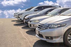 Lot of used car for sales in stock with sky and clouds photo