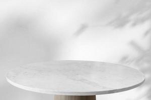 Marble table with tree shadow drop on white wall background for mockup product display photo