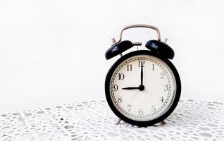 Vintage or classic clock on table isolated on white background with copy space. Retro object. 9 or nine o'clock, Morning time and Black timing or watch on wall. photo