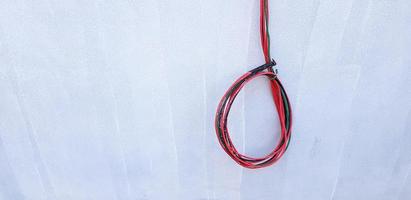 Red, Black, and Green cable hanging or isolated on gray concrete wall with copy space. New installation wiring power cord, Connection, Repair building and Electrical system industrial concept photo