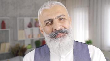 A sympathetic smiling mature man looking at the camera. Handsome man with white beard is looking at camera and smiling. video