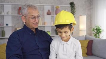 padre y hijo, hijo Ayudar padre trabajo a hogar y acecho a él. contento padre y hijo. pequeño hijo Ayudar ingeniero padre. video