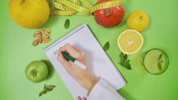 salutare vivente e nutrizione. preparare un' dieta Piano. dietista scrive dieta Piano su un' pezzo di carta. video