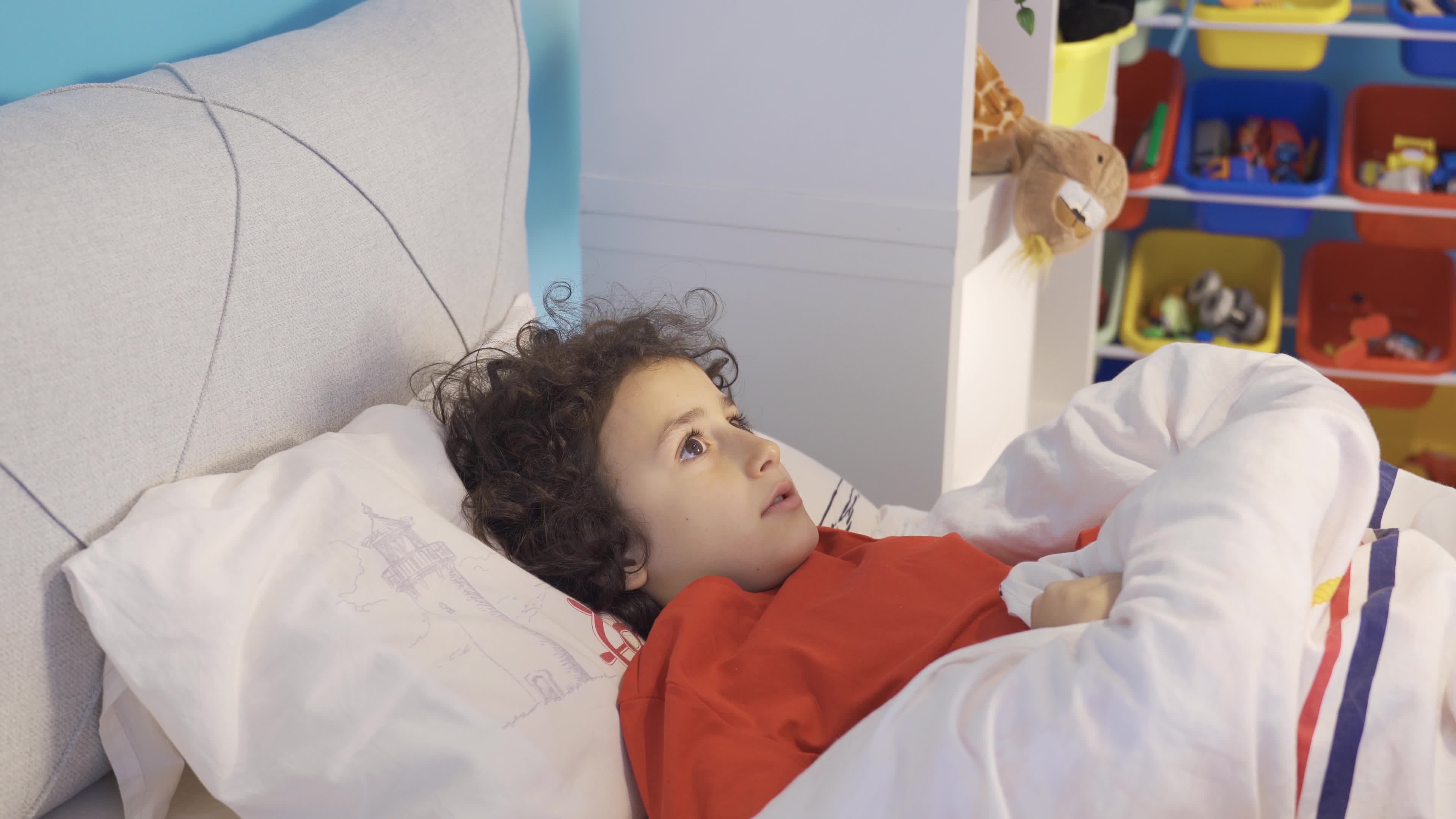 Fear of children. Boy with sleep problem. Scared little boy hiding