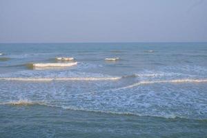 Ocean wave on the beach at sunset time. photo