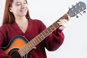 joven mujer jugando guitarra aislado en blanco antecedentes foto