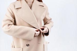 closeup woman wearing beige pastel coat in white background photo