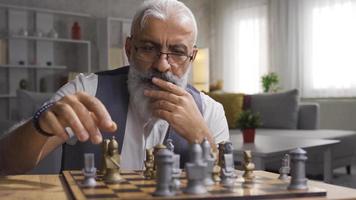 maduro hombre jugando ajedrez y desarrollando su estrategias. pensativo hombre jugando ajedrez y pensando acerca de su se mueve video