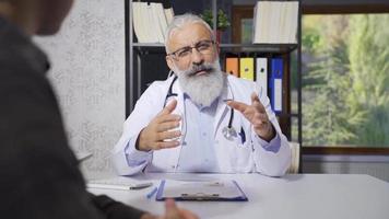 Senior médico informando dele paciente sobre dele doença. Senior maduro médico falando para dele paciente. video