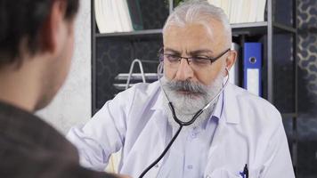 Senior doctor examining his patient with a stethoscope. Senior doctor examining with stethoscope. video