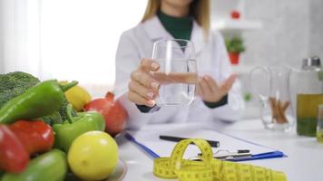 a dietista dá sugestões para uma saudável vida. a dietista recomendado bebendo água para comer saudável e fique ajustar. video