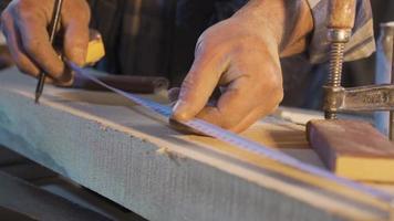 Measuring with meters. Wood measurement. The carpenter measures the wood with the meter and makes markings with a pencil. video