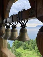 campanas en el campanario de un cristiano Iglesia en contra el fondo de lago Baikal, Rusia