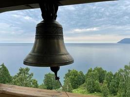 campana en el campanario de un cristiano Iglesia en contra el fondo de lago Baikal, Rusia
