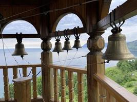 campanas en el campanario de un cristiano Iglesia en contra el fondo de lago Baikal, Rusia foto