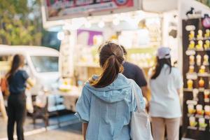 woman traveler visiting in Food Truck Market, Tourist with bag sightseeing in Weekend Market street photo