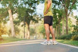 man jogging and walking on the road at morning, adult male in sport shoes running in the park outside. Exercise, wellness, healthy lifestyle and wellbeing concepts photo