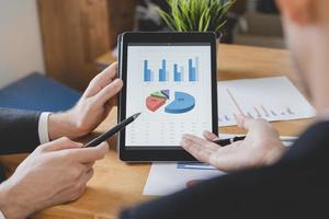 Business meeting, two caucasian, asian group man use pen, brainstorm analyzing on graph data of cost plan or document, paperwork and discussing in board room on table. People working conference room. photo