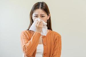 Sick, Coronavirus covid asian young woman, girl have a fever, flu, hand in use tissues paper sneezing nose, runny and cough, standing on isolated background. Health care to disease influenza seasonal photo