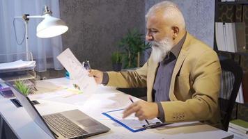 Businessman examining and comparing charts. Businessman working on computer and graphs in his office making comparisons. video