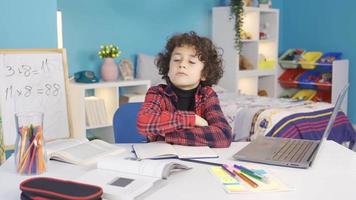 moe van intens en vermoeiend klassen, de jongen is beduusd. verveeld en moe van aan het studeren en aan het doen huiswerk, de mannetje leerling duurt een breken en denkt na. video