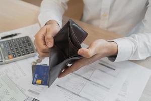 Stressed, Problem people asian man, male holding and open an empty wallet not have money, credit card, not to payment bill, loan or expense in pay. Bankruptcy, bankrupt and debt financial concept. photo