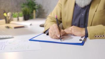 Businessman graphing financial expense statement. Male hand in suit drawing financial statement on paper on office desk. video