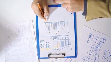 Businessman draws graph with his hands. Businessman Sitting At His Desk In The Office Analyzes And Draws Charts.