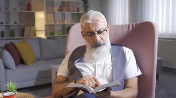 Mature man reading historical book, researching and contemplating. Mature man reading books loves to read and learn. video