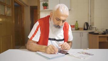 homme calcule à Accueil avec calculatrice et regards à factures. travail homme en essayant à Payer factures. video