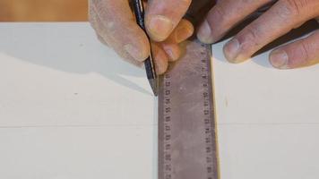 Carpenter's Hands Measures the board with a ruler. Senior carpenter hands measure a wood with a ruler in workshop. video