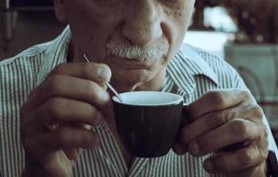 mayor hombre Bebiendo Café exprés café a un al aire libre café foto