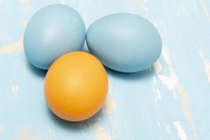 huevos simbolizando el Pascua de Resurrección fiesta en azul y naranja color en un antecedentes de Envejecido madera foto