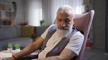 Senior reifen Mann ist nachdenklich und nachdenklich. reifen Mann nachdenklich spielen mit seine Bart und suchen um. video