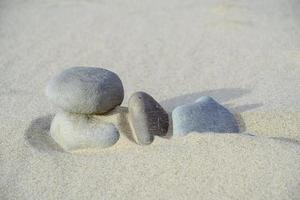 las piedras están cubiertas de arena de cuarzo en la playa durante el viento fuerte.