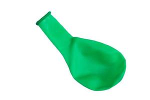 Green balloon without air to inflate isolated on white background. Concept,  toy and equipment to play fun games or prepare party. Deflated balloon. photo