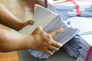 Closeup hands hold stack of used paper to recycle or combine to use next time to print out both sides of paper. Concept, eco friendly activity for environment, reuse paper. photo