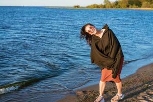 Portrait happy smiling woman on beach. Smiling sensual brunette posing photo